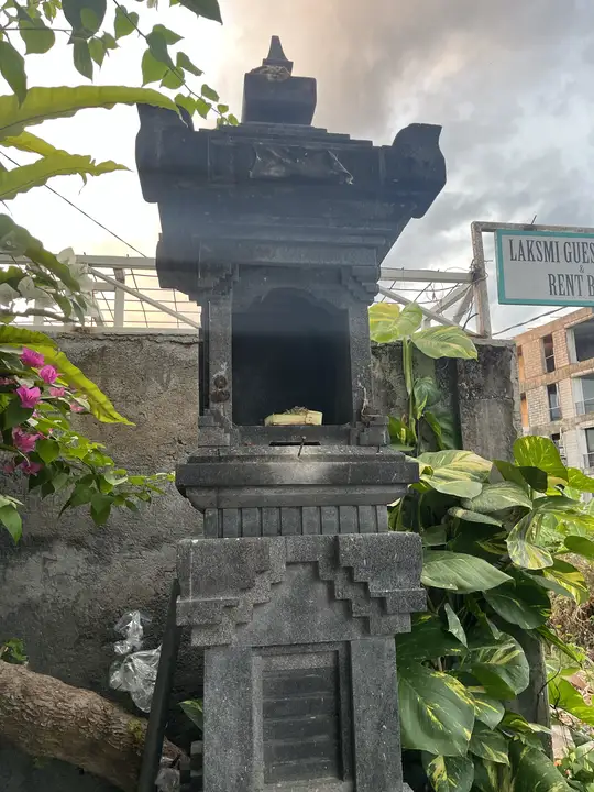 A household shrine at sunrise, with the first offering of the day inside.